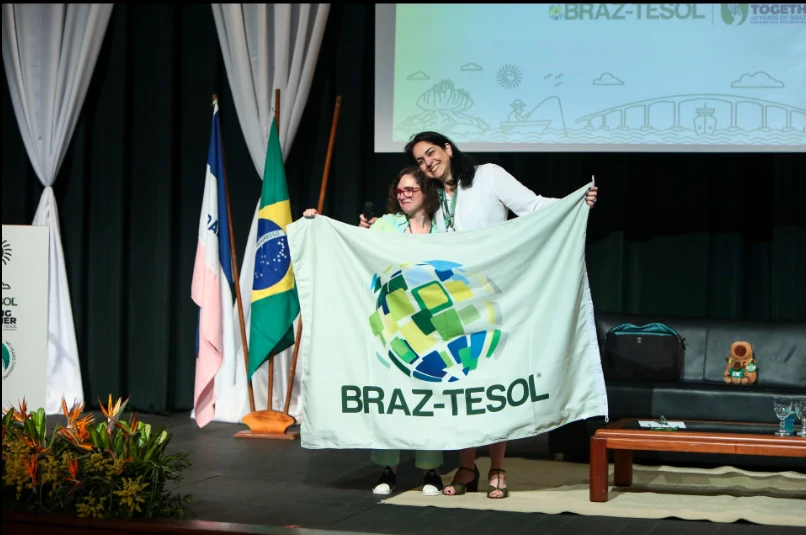 Participants holding the BRAZ-TESOL flag on stage